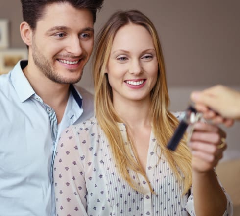 image of a couple receiving a set of keys, they take the key knowing that they are covered by the best Renters' Insurance polcy in Knoxville, TN